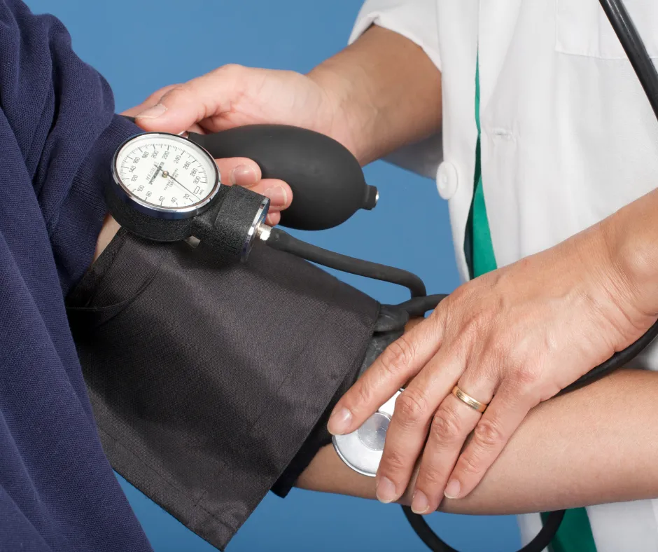 A healthcare professional taking a patient's blood pressure using a sphygmomanometer.